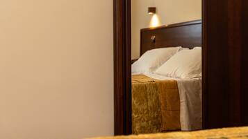 Un dormitorio con cabecera de madera, cama con almohadas blancas y manta amarilla.