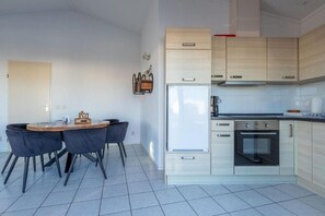 Enjoy meals in the kitchen and dining area, featuring a stainless steel oven, microwave, and round dining table.