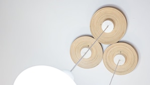 A ceiling light fixture with three circular wooden elements and a large white bulb. - Venus Apartments - Oktogon I (Budapest)