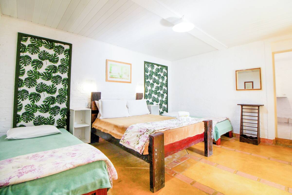 A room with two beds, a small table, and a ladder.