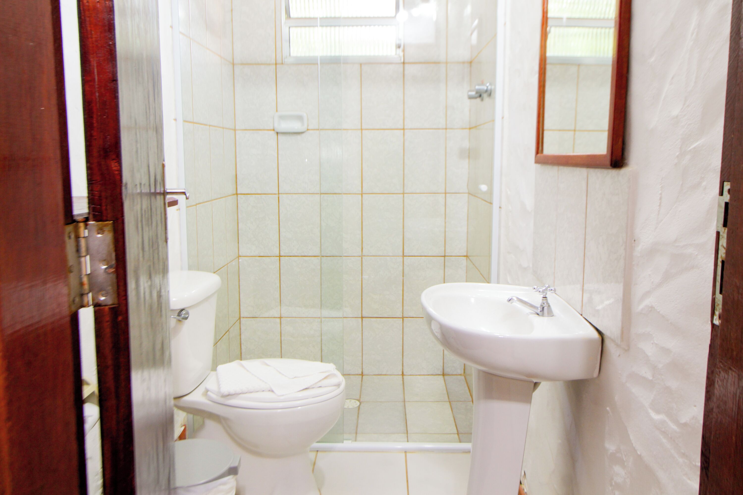 A bathroom with a toilet, sink, and shower.