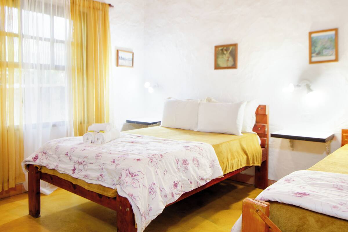 A room with a bed, a wooden nightstand, and a chair.