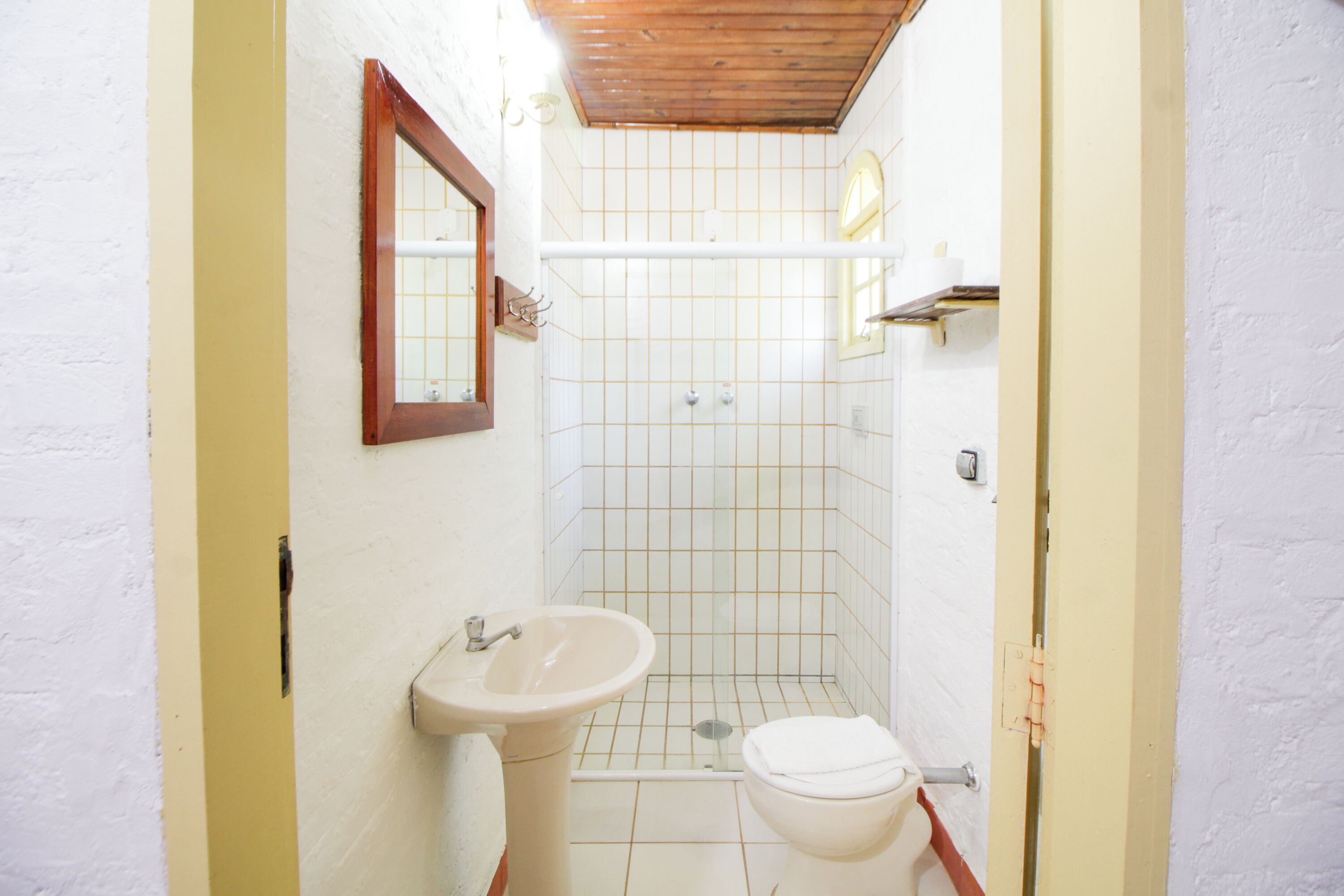 A small bathroom with a sink, toilet, and shower.