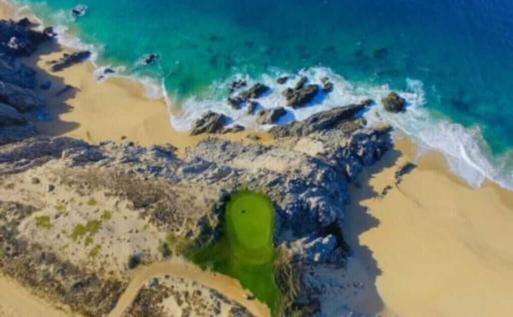Vue aérienne d’une plage avec un terrain de golf.
