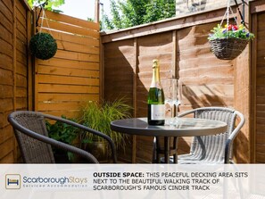 Enjoy a refreshing drink on the deck, surrounded by lush greenery and overlooking the scenic walking track.