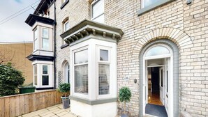 Une maison d’angle avec une baie vitrée, une porte et un mur en briques.