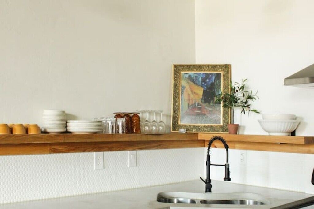 Een keuken met een houten aanrecht, een spoelbak en een lijst met een foto erboven.