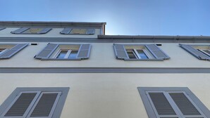 A building facade with multiple windows and shutters.
