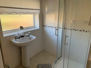 A bathroom with a sink, mirror, and shower. - Stunning 3-bed House in Cheadle (Cheadle)