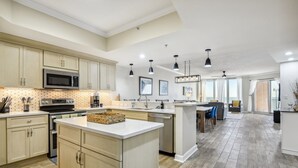 Cozinha espaçosa com eletrodomésticos modernos, ilha central e área de jantar com vista.