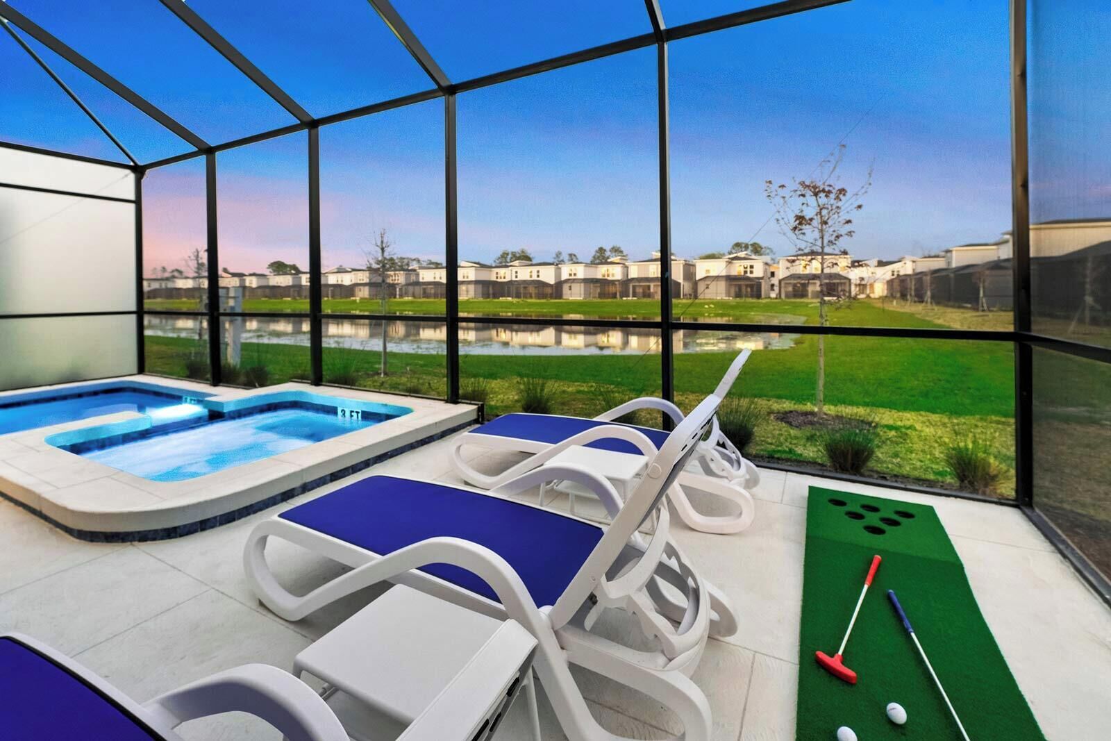 Un espace piscine intérieur moderne, doté d’un jacuzzi, de chaises longues et d’un terrain d’entraînement au putting.