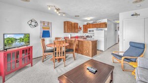 A compact living space with a kitchen, dining area, and seating. - Oceanfront Condo Amazing Views, Charming Nautical Theme, Covered Deck (Newport)