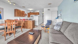 A compact living space with a kitchenette, a dining area, and a seating area. - Oceanfront Condo Amazing Views, Charming Nautical Theme, Covered Deck (Newport)