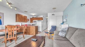 A compact living space with a kitchenette, a dining area, and a seating area.
