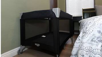 A bunk bed with a Cosco brand mattress, a small table beside it, and a patterned bedspread.