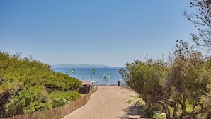 A sandy beach path leading to the sea with boats and windsurfers. - Résidence Odalys Riviera la Presqu'Ile (Hyères)