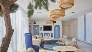 A modern living room with a large window, a fireplace, and a television. - Résidence Odalys Riviera la Presqu'Ile (Hyères)