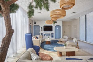 Una sala de estar moderna con un ventanal grande, chimenea y televisor.