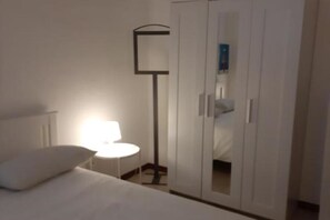 A bedroom with a bed, a nightstand, a lamp, and a wardrobe. - Apartment A.D. 3 (Alessandria)