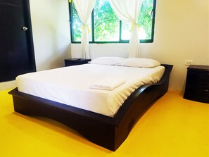 Cozy retreat with a single bed, two nightstands, and a window with a curtain.