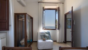 A room with a view of the sea, a wooden wardrobe, a small table with a hat, and a chair. - Villa Ai Venti 8, Emma Villas (Massarosa)