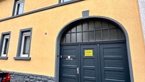 A building with a yellow facade and a dark blue door with a sign that reads "Eintritt freihalten". - Stylisches 1 Zimmer Apartment (Ludwigshafen am Rhein)