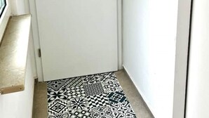 A narrow hallway with a patterned floor and a white door. - Stylisches 1 Zimmer Apartment (Ludwigshafen am Rhein)