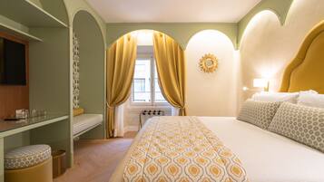 Une chambre d’hôtel avec un lit, un bureau, une chaise et une fenêtre avec des rideaux.