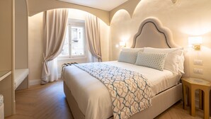 A bedroom with a large bed, a window with curtains, and a nightstand with a lamp. - La Dimora del Mercante (Florence)