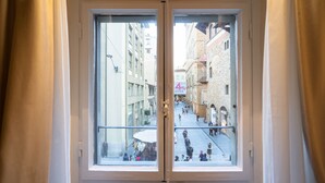 A window with a view of a narrow street with buildings and pedestrians. - La Dimora del Mercante (Florence)