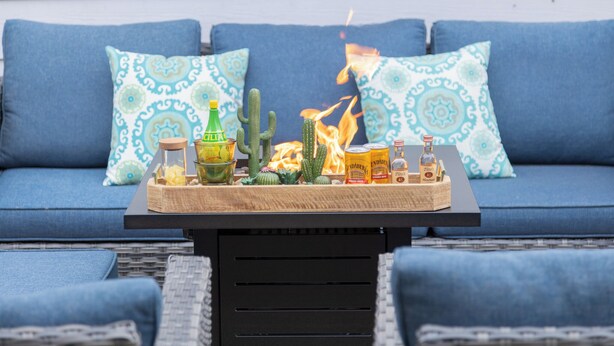 A blue sofa with patterned cushions, a wooden table with a glass jar, a bottle, and a small cactus. - Restaurants, Cafes & Close to Downtown & Coronado (San Diego)