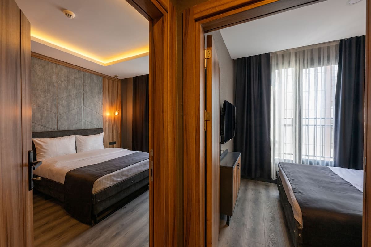 A hotel room with a large bed, a TV, and a desk.
