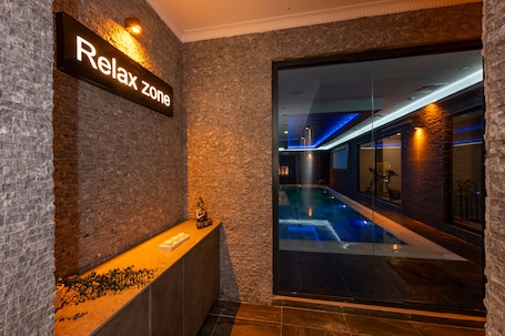 Una piscina techada, sillones reclinables de piscina