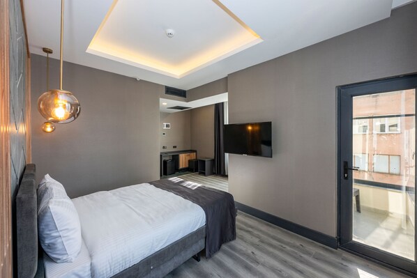A modern hotel room with a bed, a TV, a desk, and a balcony.