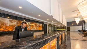 A hotel reception desk with a marble counter and a receptionist. - The Nirvanas Hotel (Istanbul)