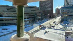 A view from a window overlooking a parking garage with multiple levels and a clear sky. - Modern private One bedroom apartment Calgary Downtown #502 (Calgary)