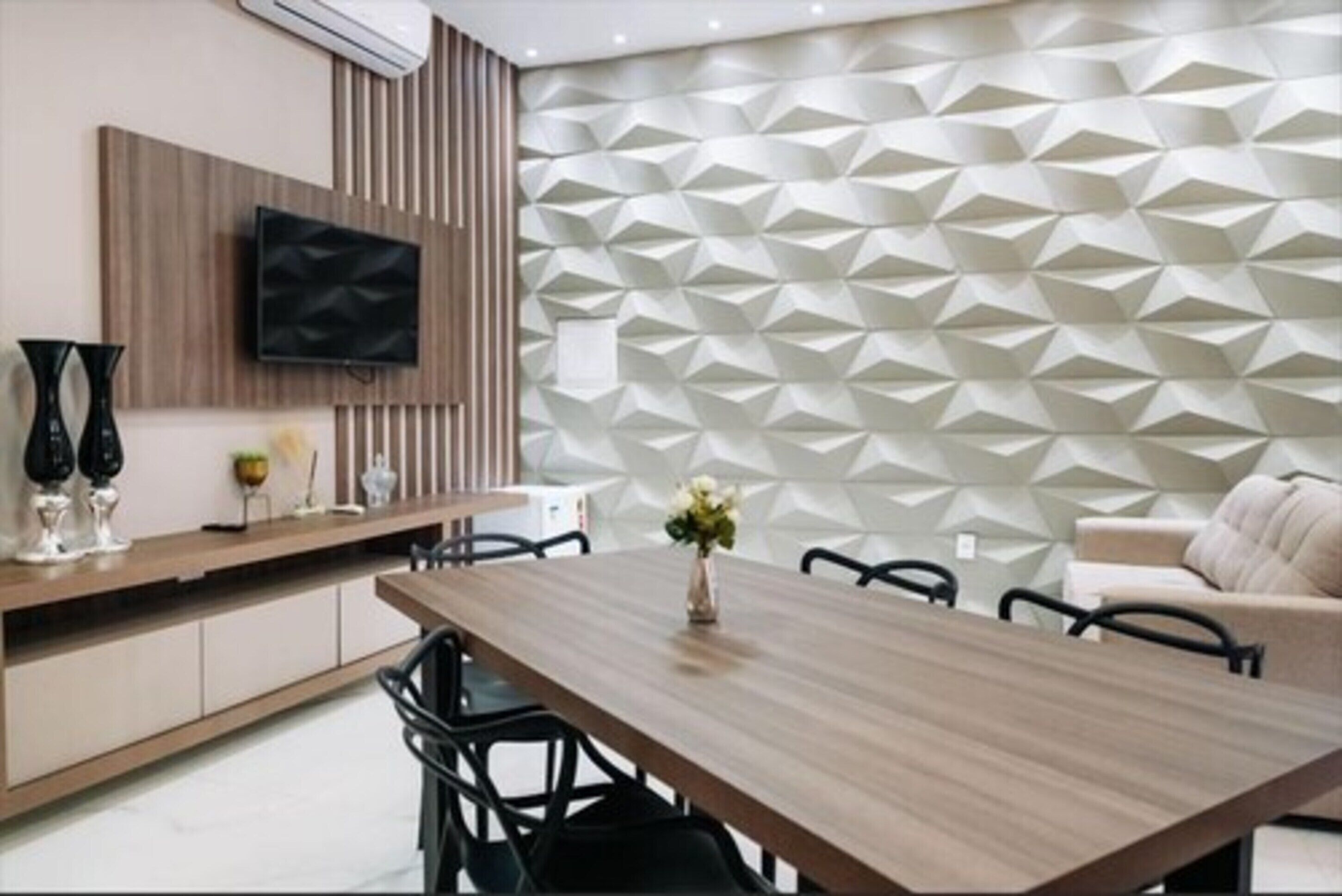 Un comedor moderno con una mesa de madera, sillas y una pared decorativa con patrones geométricos.