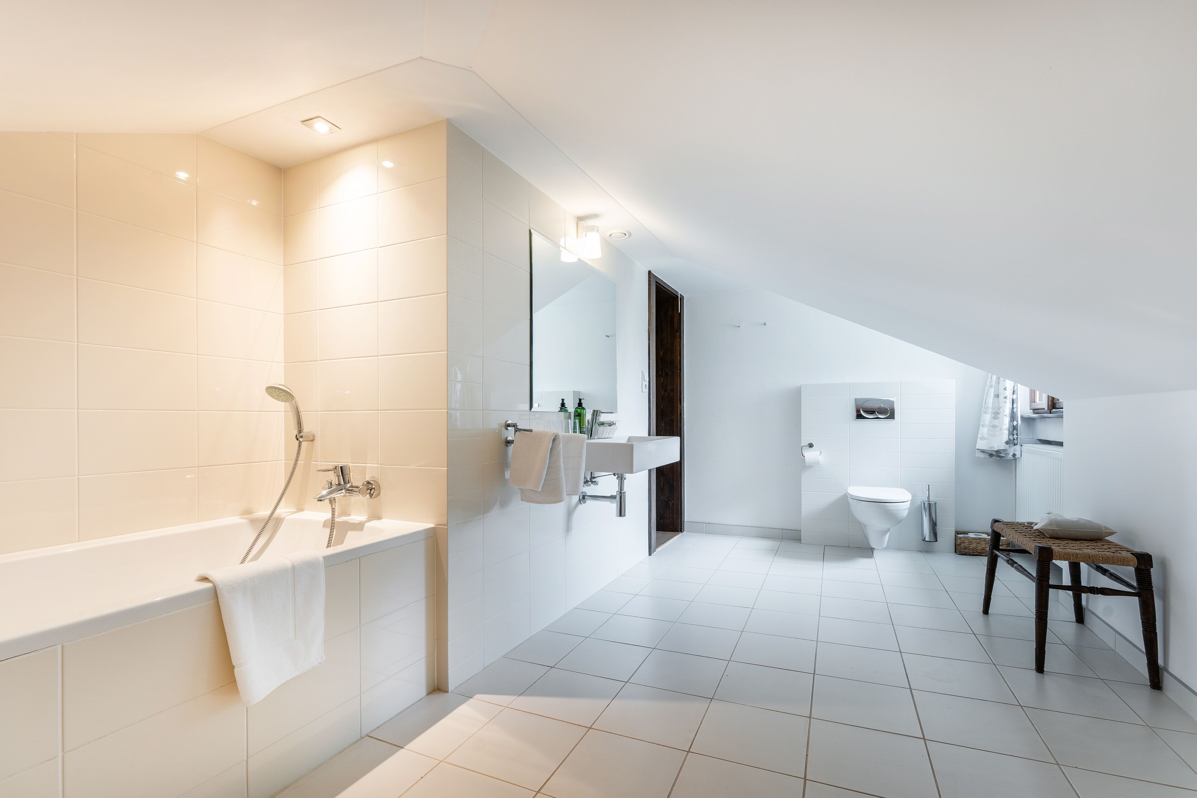 A modern bathroom with a freestanding bathtub, a vanity with a mirror, and a toilet.