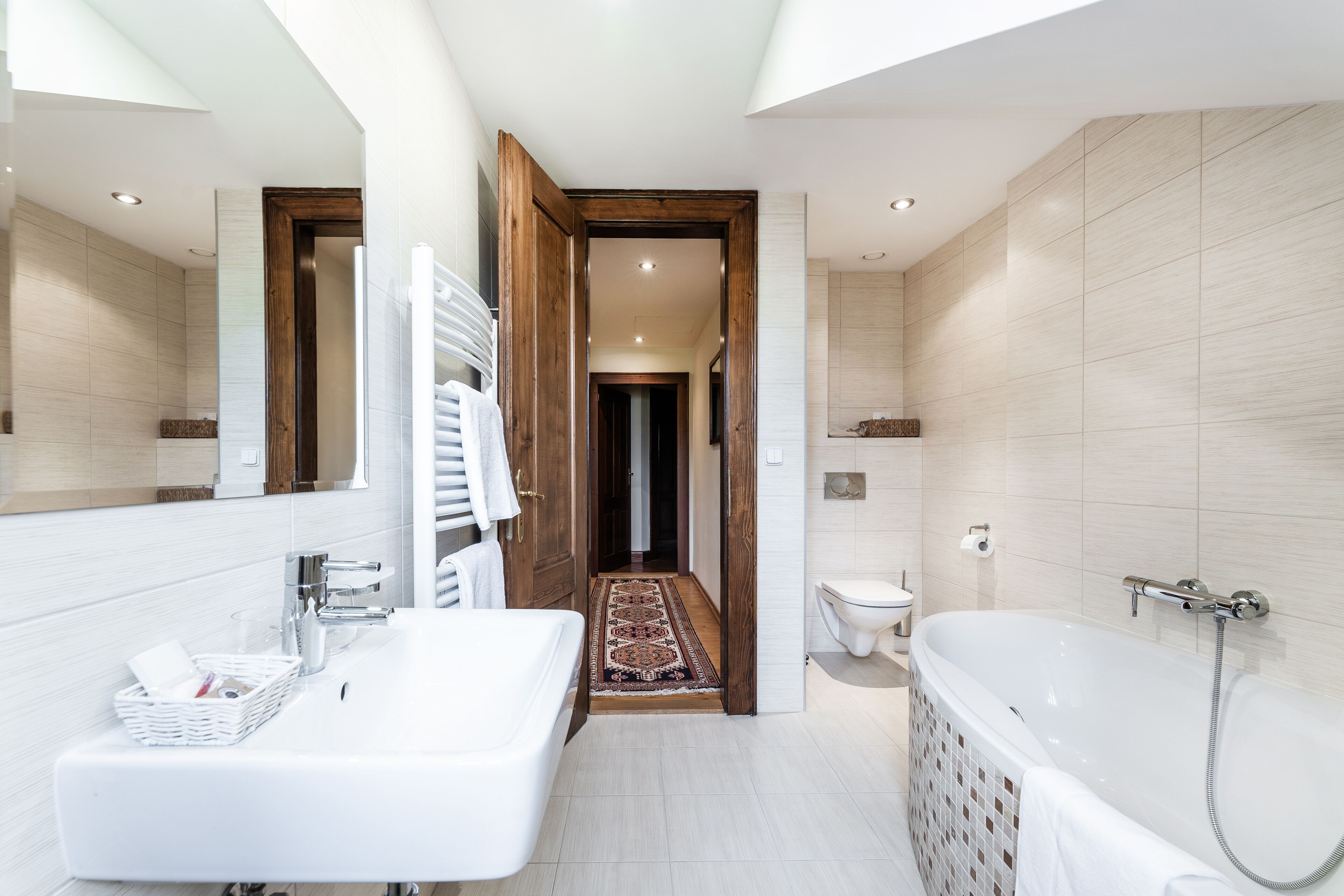 A modern bathroom with a double sink, a large bathtub, and a walk-in shower.