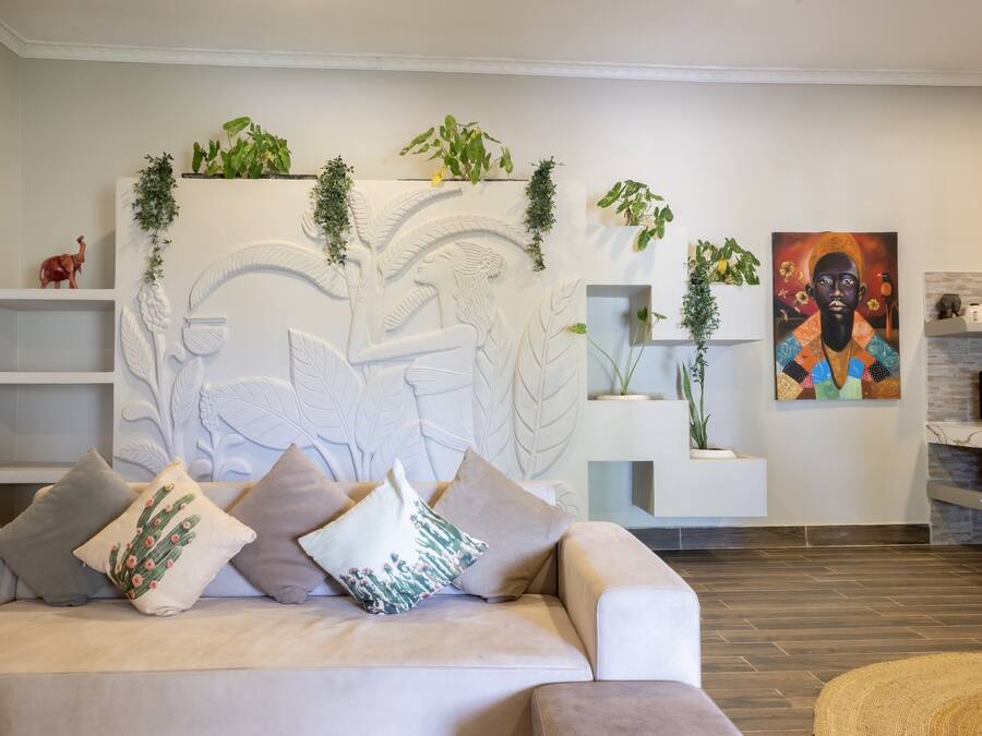 Sala de estar con sofá, decoración en la pared y un cuadro.