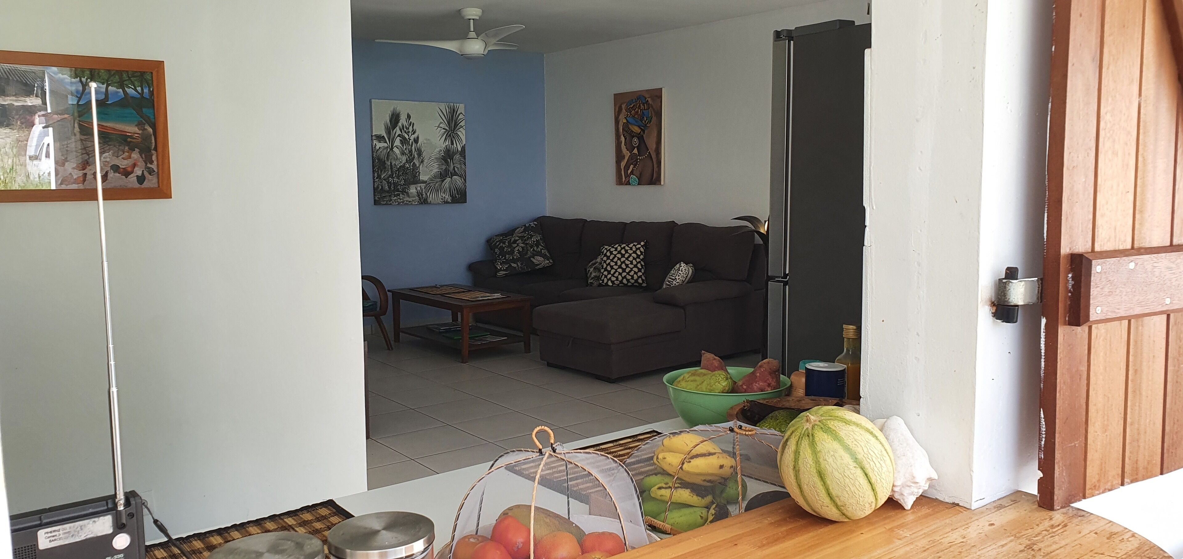 Una sala de estar con un sofá, una mesita de centro y una cesta de fruta.