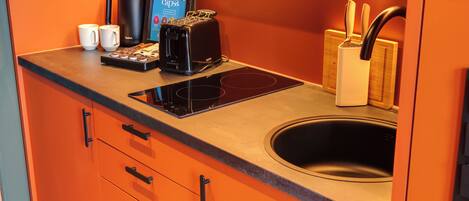 A kitchen with a coffee maker, toaster, and a digital screen displaying a menu.