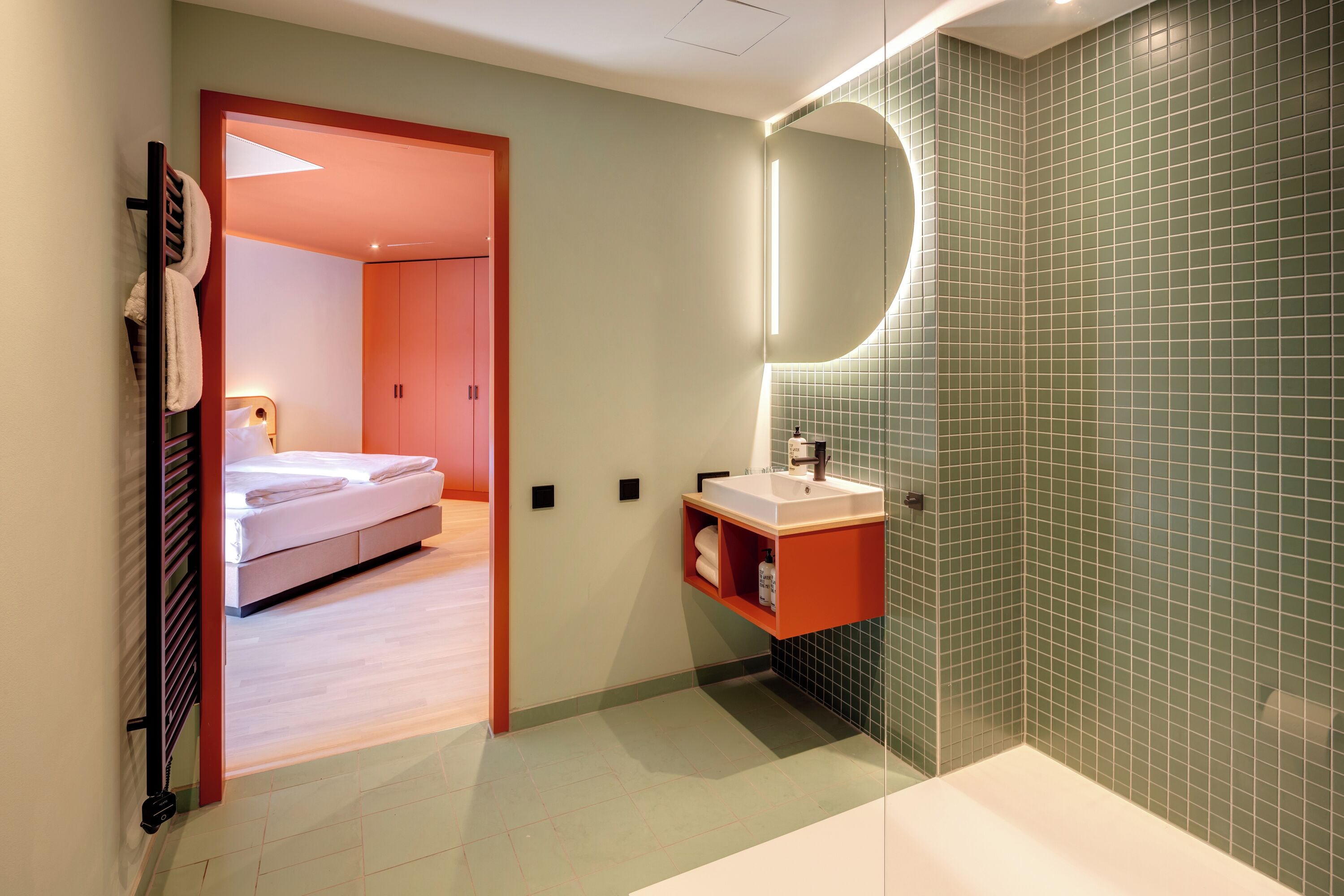 A modern bathroom with a shower, a sink, and a mirror.