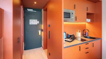 A compact kitchen with a microwave, sink, and countertop appliances.