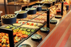 A buffet with various food items including sliced vegetables, meats, and cheeses. - DEIN APART München (Unterfoehring)