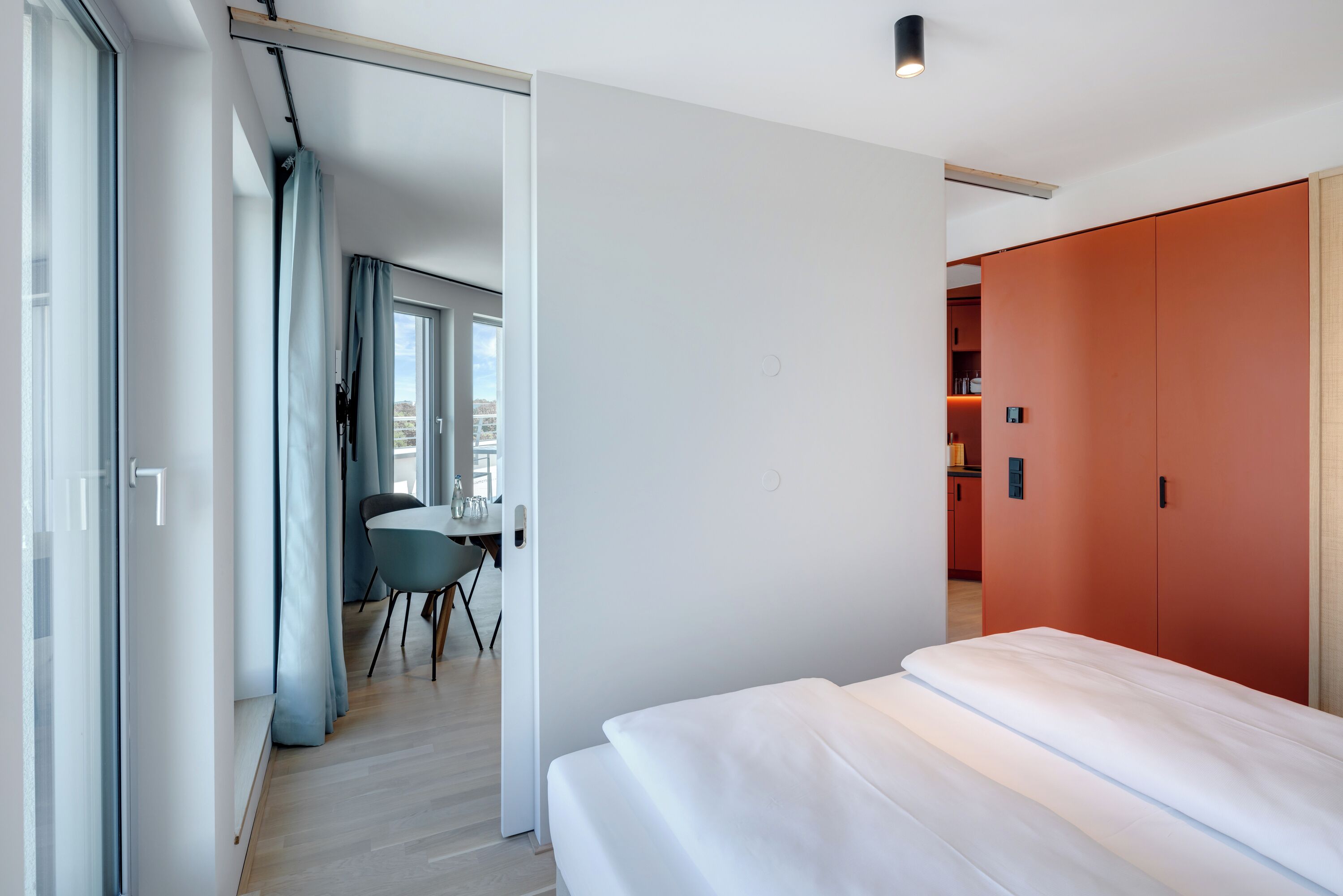 Quarto de hotel moderno com uma cama, uma escrivaninha e um guarda-roupa.