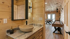 A wooden cabin interior with a large wooden-framed mirror, a stone basin sink, and a wooden dining table with benches. - Private Mountain Cabin Retreat 1.5 acres, Amazing Views, Hot Tub, STARLINK Wifi (Murphy)