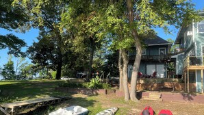 Propiedad frente al lago con muelle, kayaks y una casa con terraza.