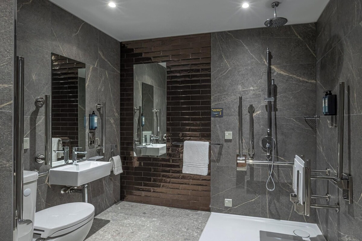 Une salle de bain moderne équipée de toilettes, d’un lavabo et d’une baignoire.