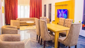 Una sala de estar moderna con sofá, mesa de comedor y sillas.